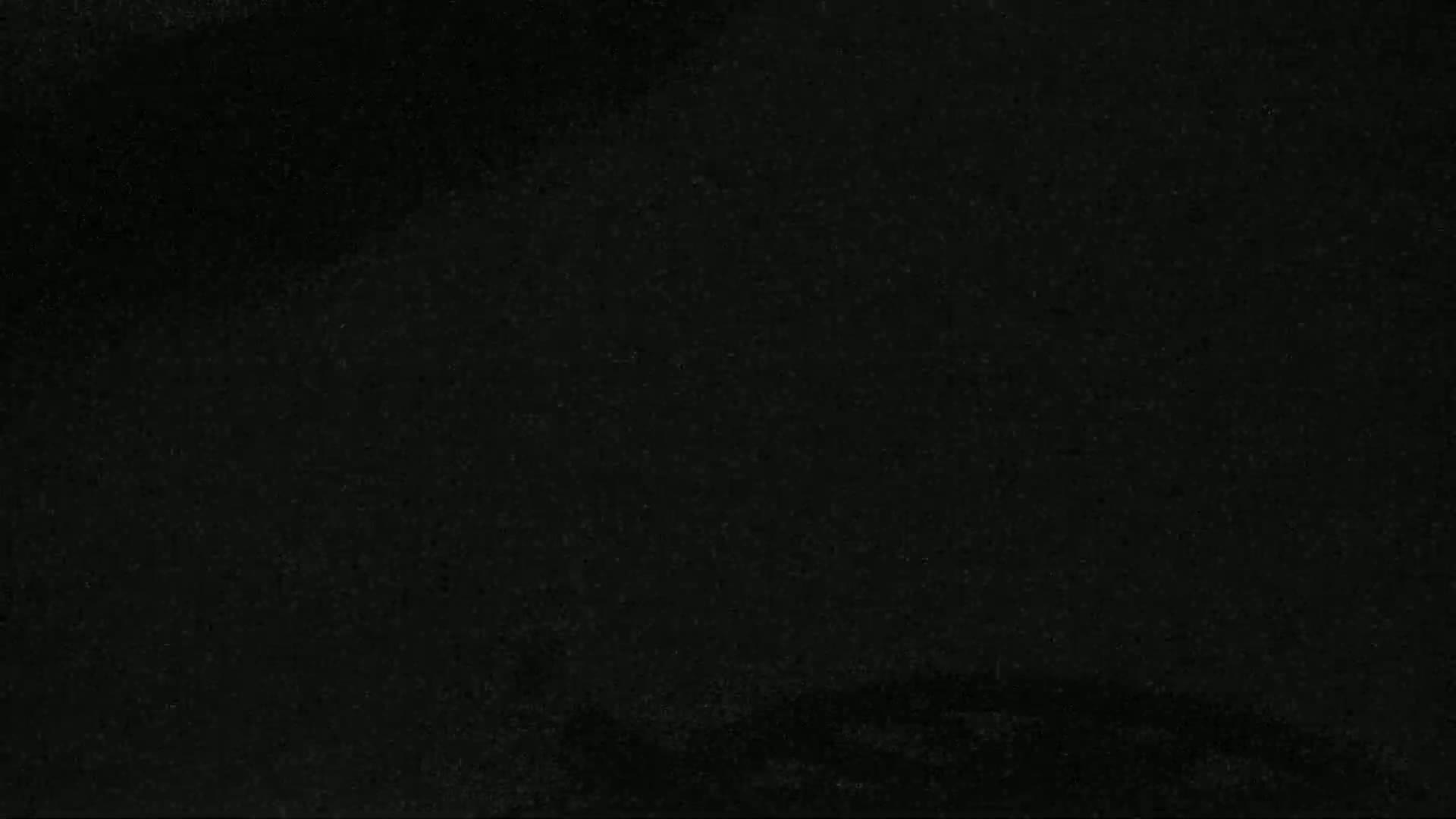 The image shows a dark, textured surface that appears to be very dark grey or black.