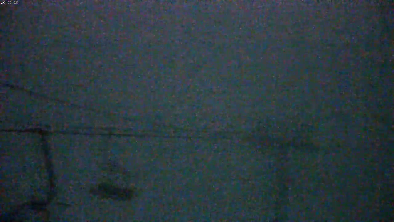 A blurry, dark image shows what appears to be a ski lift under heavy snowfall at night.