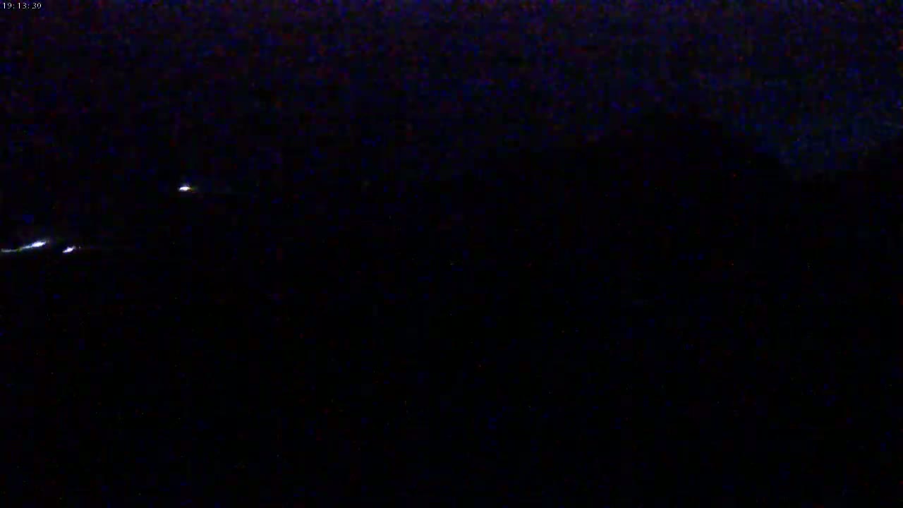 A nighttime outdoor scene shows a few distant, faint lights in an otherwise dark sky.