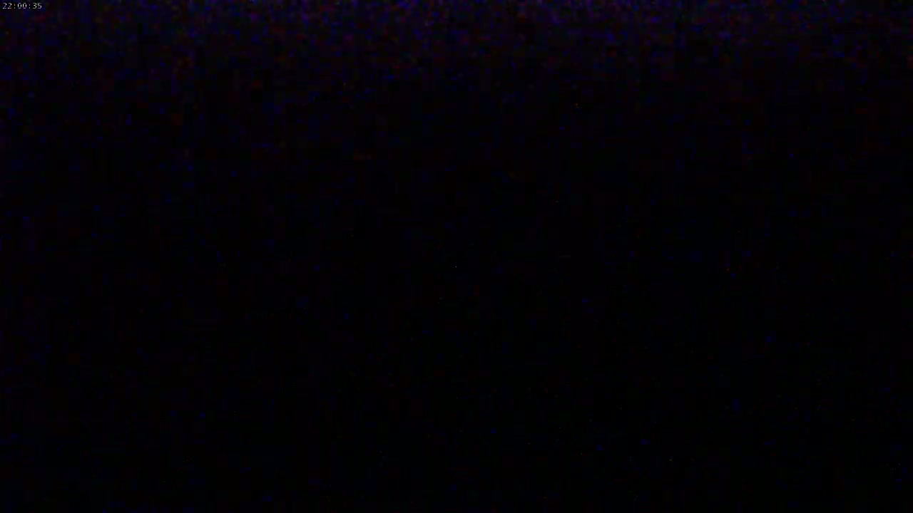 The image shows a completely black screen with subtle hints of blue and red speckles.