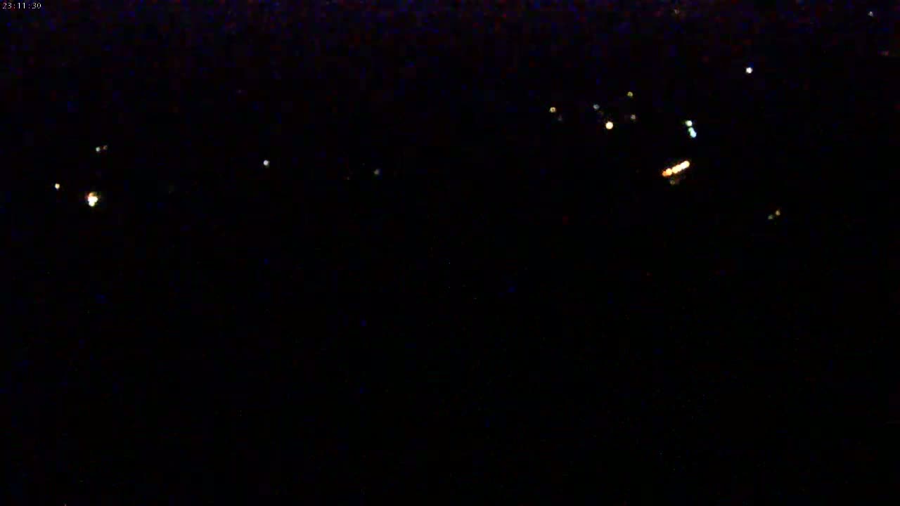 A nighttime, low-light view shows a scattering of small, distant lights against a completely dark sky.
