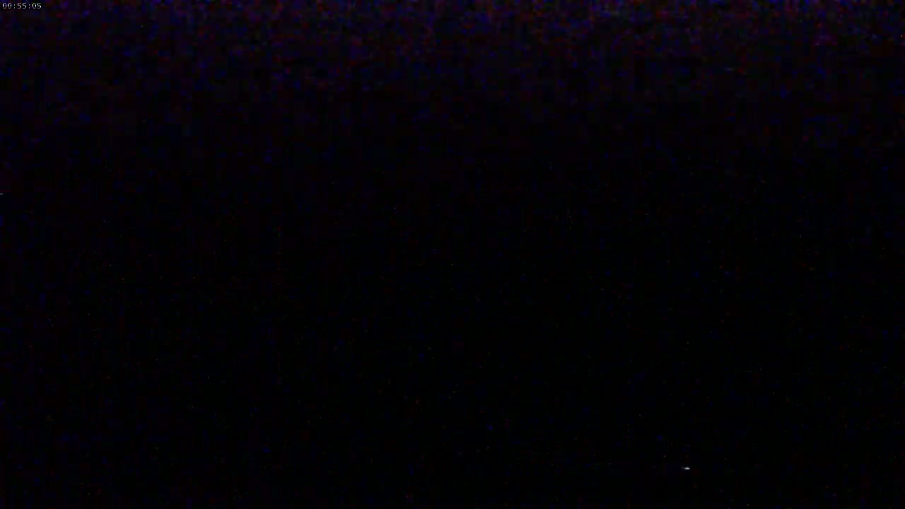 The image shows a completely dark scene with a few barely visible specks of light.