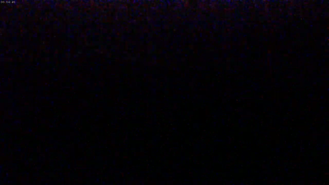 The image shows a completely black screen with a few specks of color.