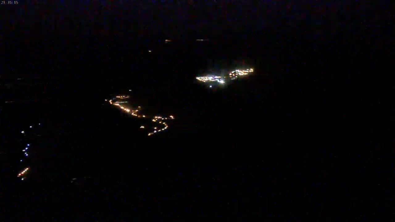 Scattered clusters of lights are visible at night from a high vantage point.