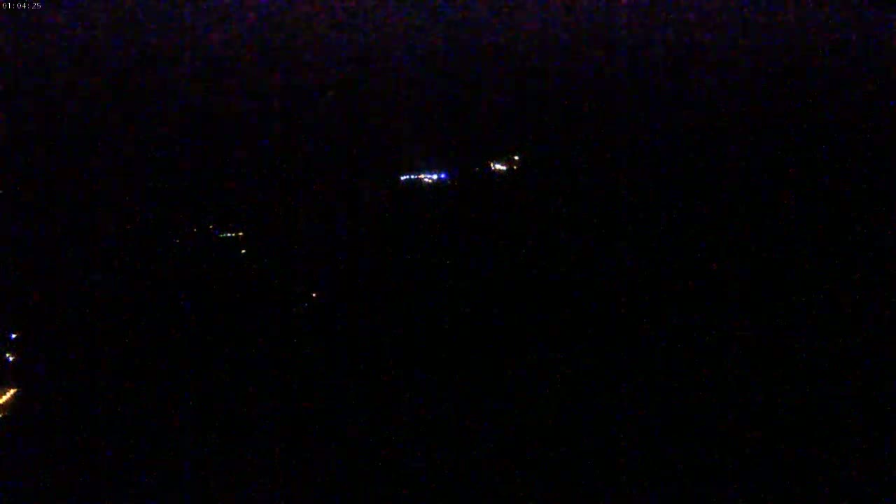 Faint lights are visible in the distance at night.
