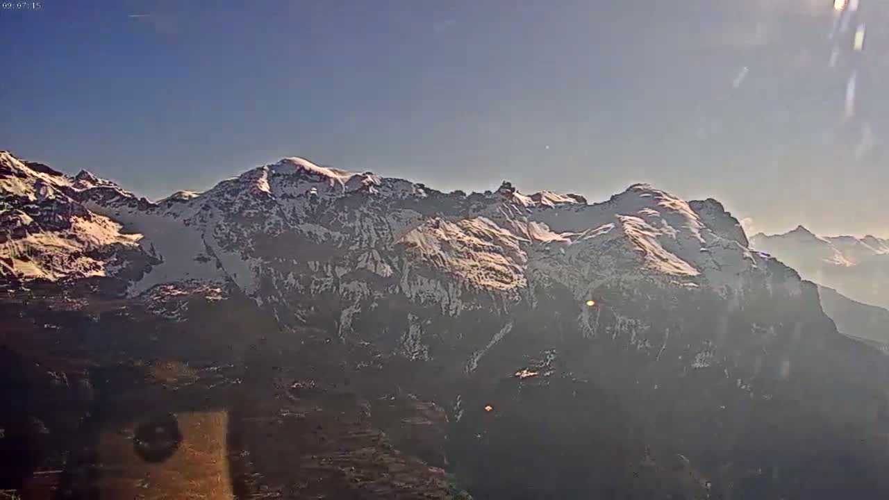 A snow-capped mountain range is visible under a clear blue sky.