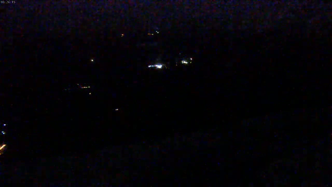 A nighttime, low-light view shows a scattering of faint lights in the distance.