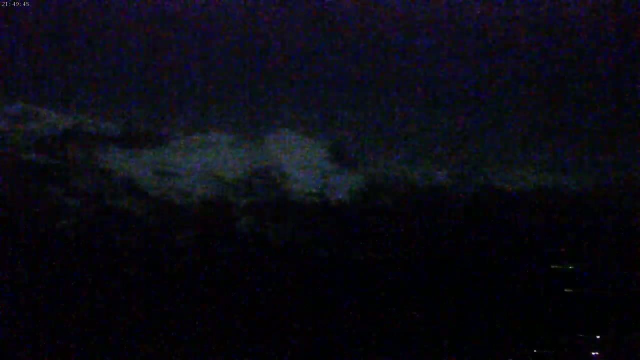 A nighttime, low-light image shows a dark sky with faintly visible clouds.