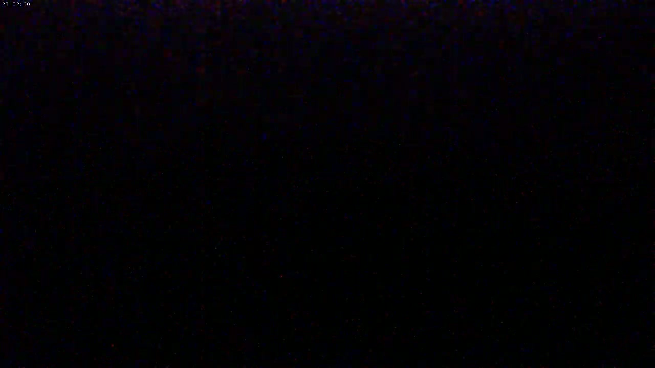 The image is almost entirely black, with a few barely visible specks of color.