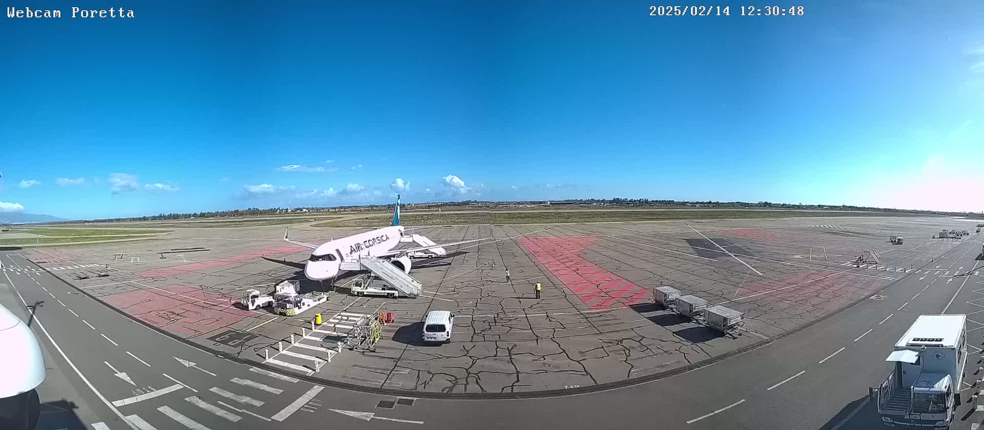 A white Air Corsica airplane is parked on a tarmac at an airport on a sunny day with a few scattered clouds.