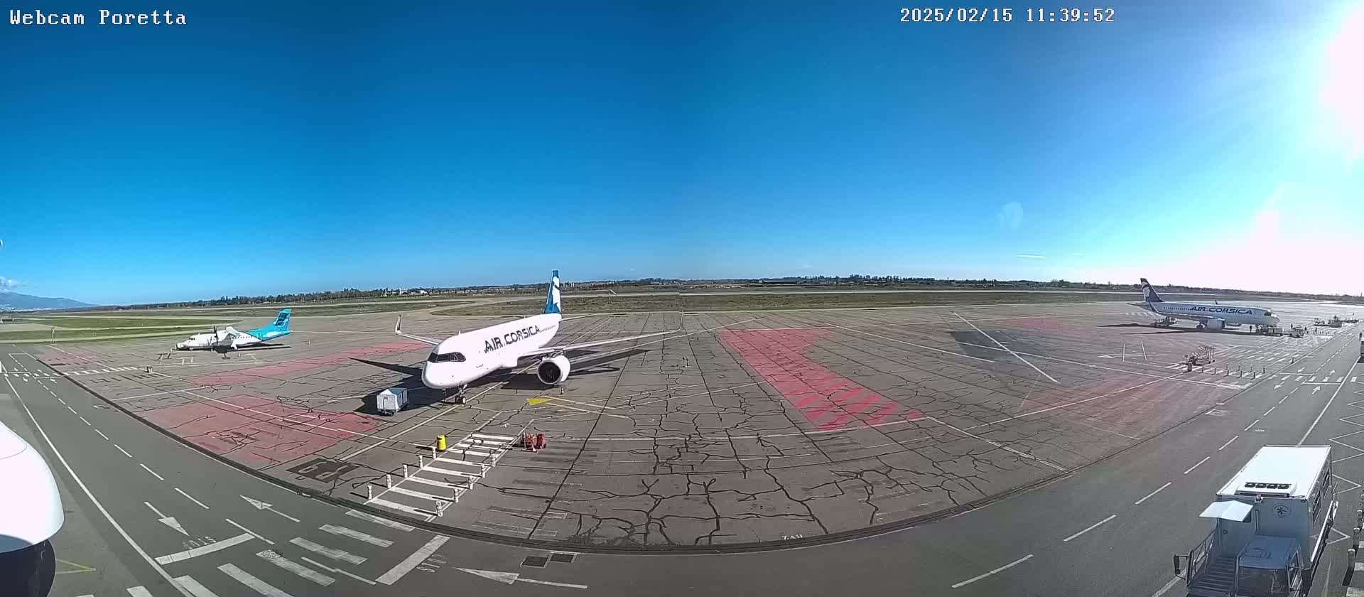 Three airplanes are parked on a tarmac on a sunny day.