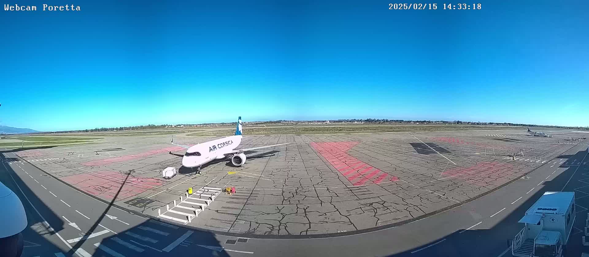 A white Air Corsica airplane sits on a tarmac under a clear blue sky.