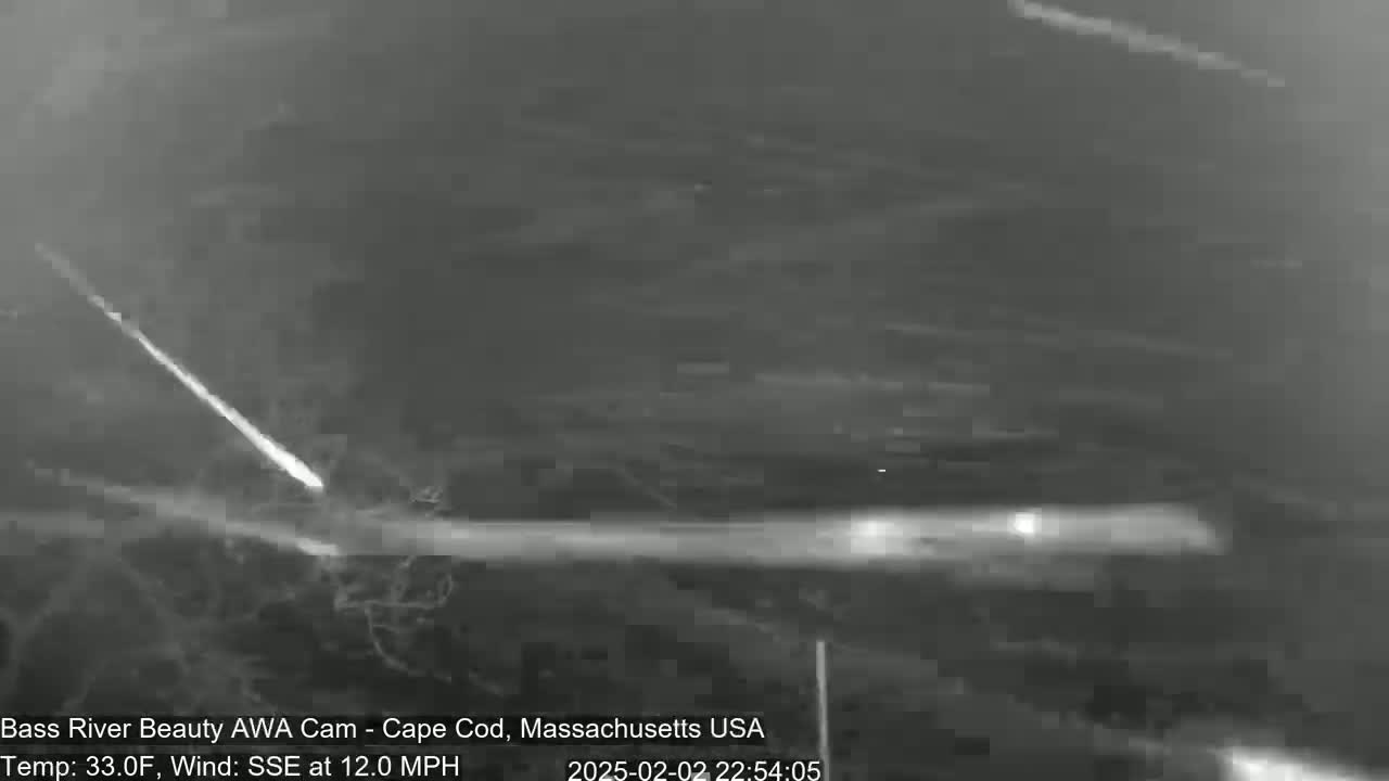 A bright meteor streaks across a night sky with a 33°F temperature and a 12 mph wind from the south-southeast.