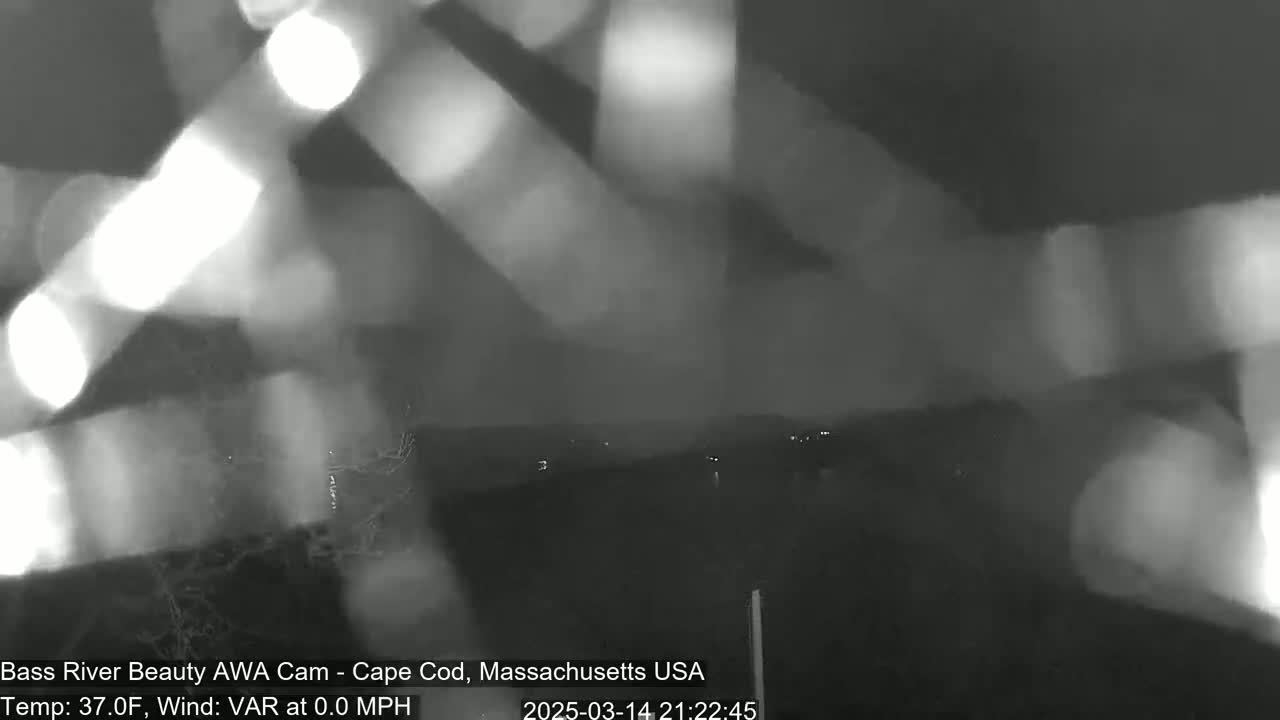 A blurry, nighttime image shows lights and indistinct shapes in the distance, with a temperature of 37 degrees Fahrenheit and a wind speed of 0.0 mph.