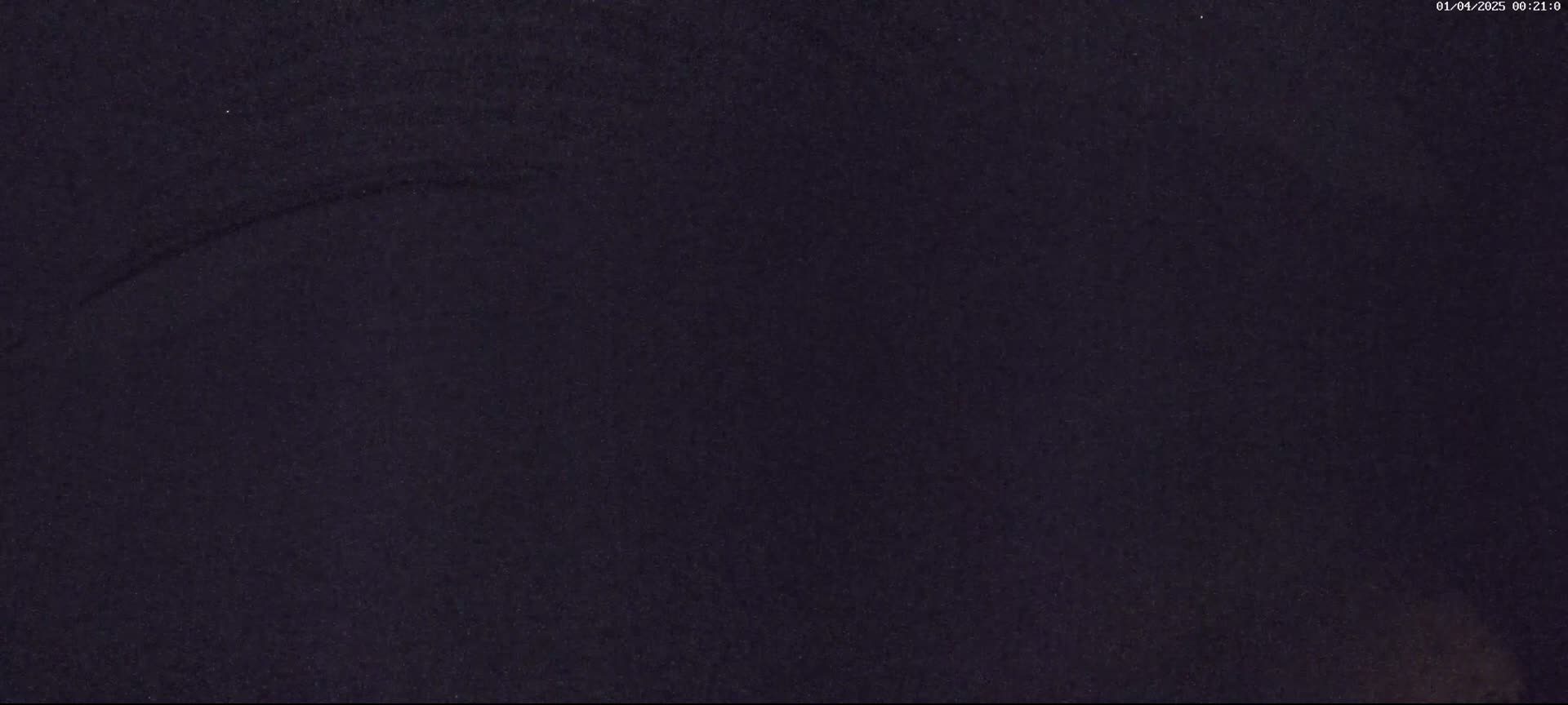 A dark, grainy image shows a mostly-uniform dark-blue/black surface with a faint, curved scratch mark.