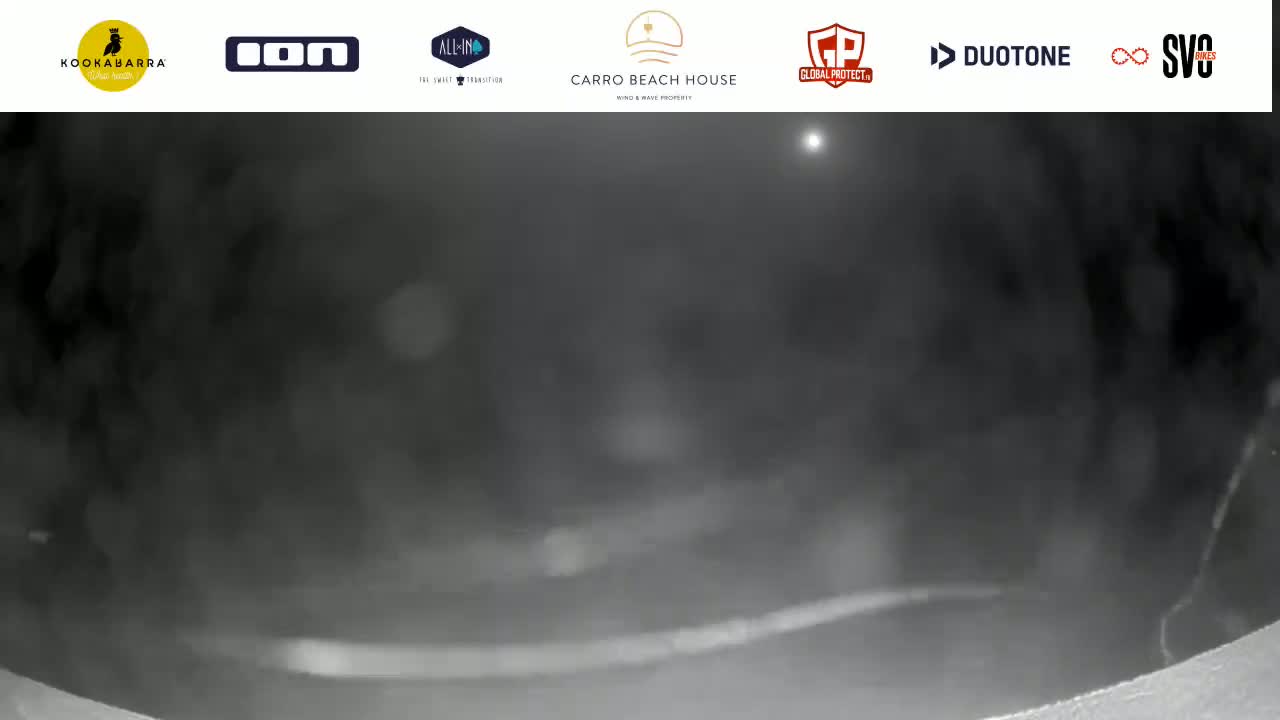 A blurry, nighttime image shows a dark, hazy scene with a faint, bright light in the distance.