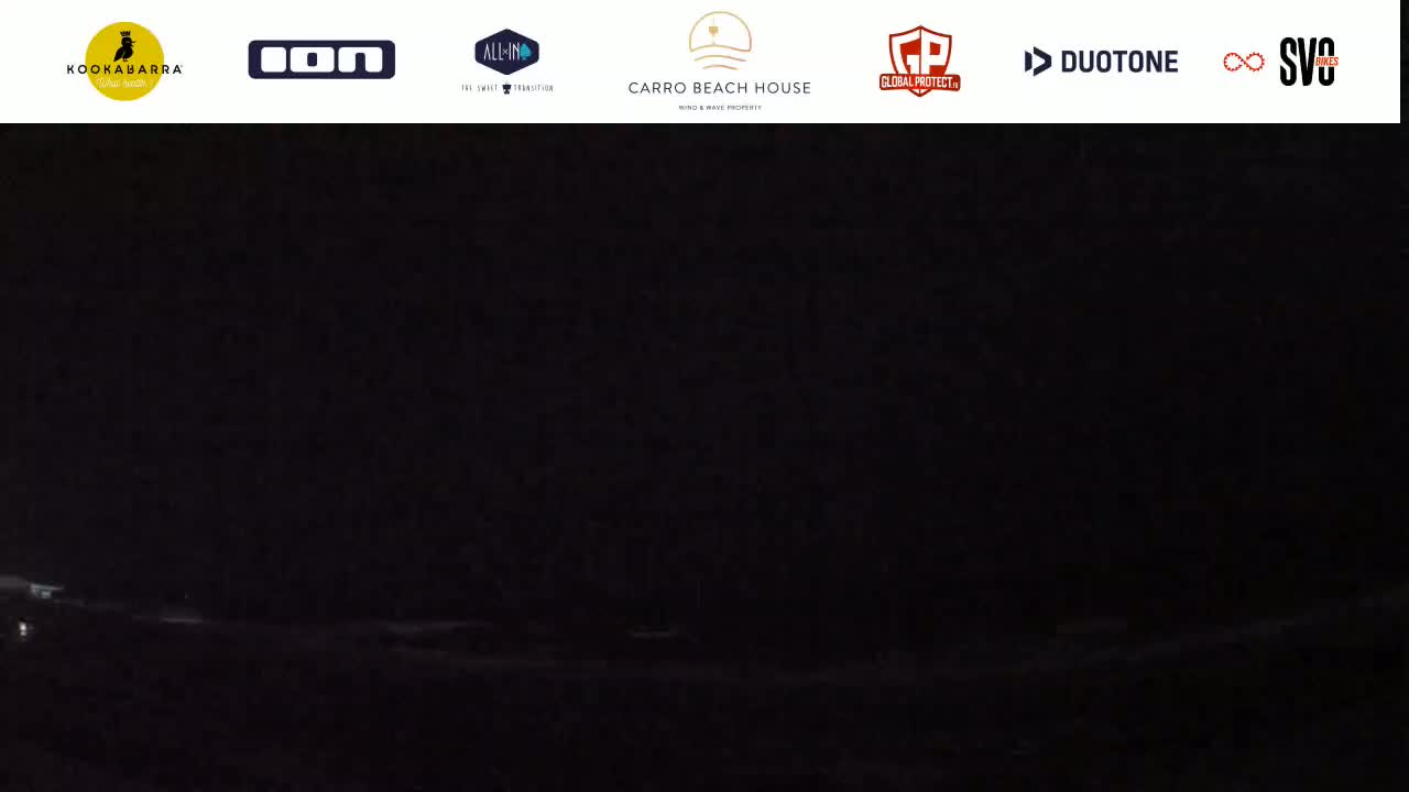A dark, nighttime scene shows a body of water under a completely overcast sky.