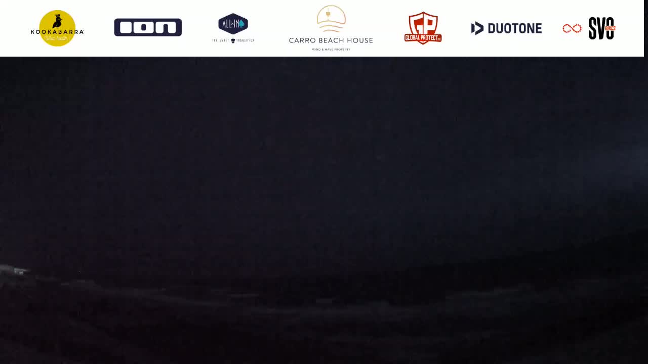 A dark, nighttime scene shows a body of water under a mostly clear, dark sky.