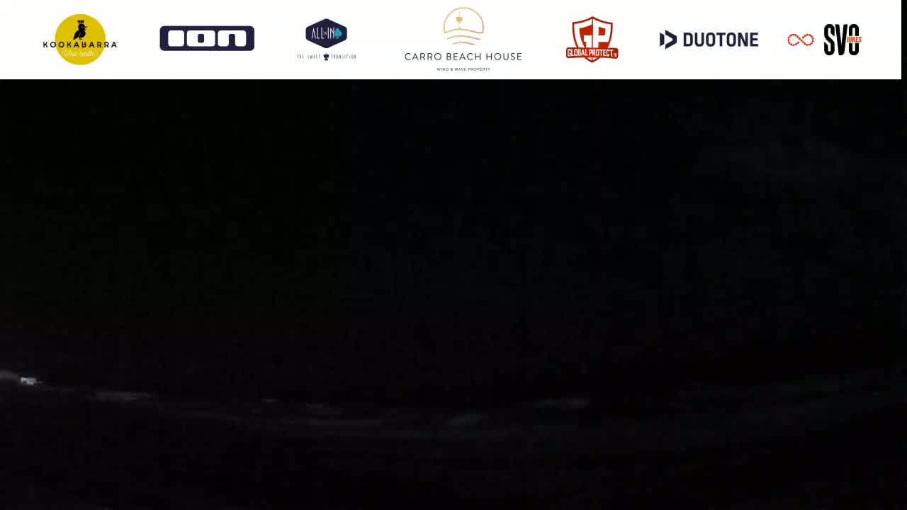 A dark, nighttime ocean scene shows faintly lit waves.