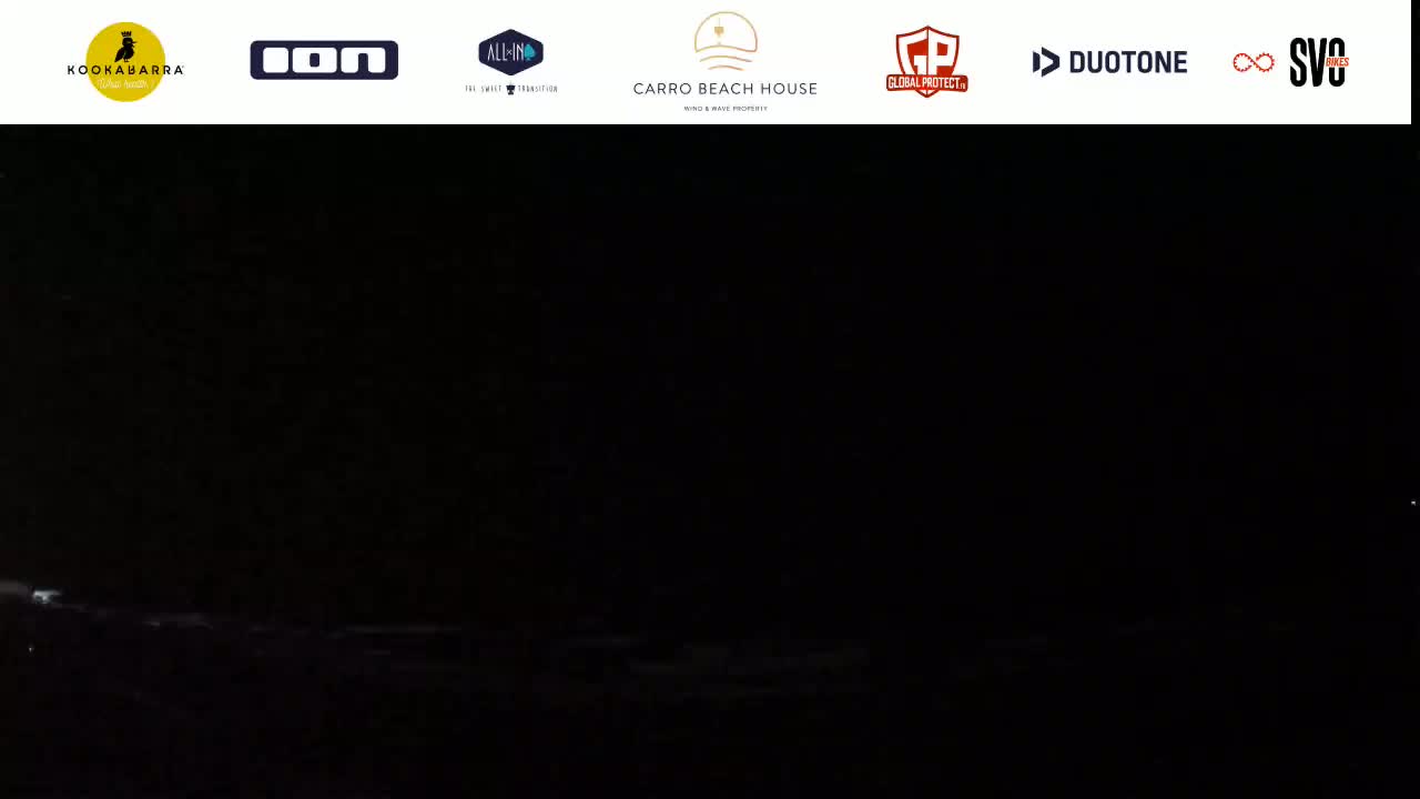 A dark, nighttime scene shows a mostly black expanse with faint, indistinct features near the bottom.