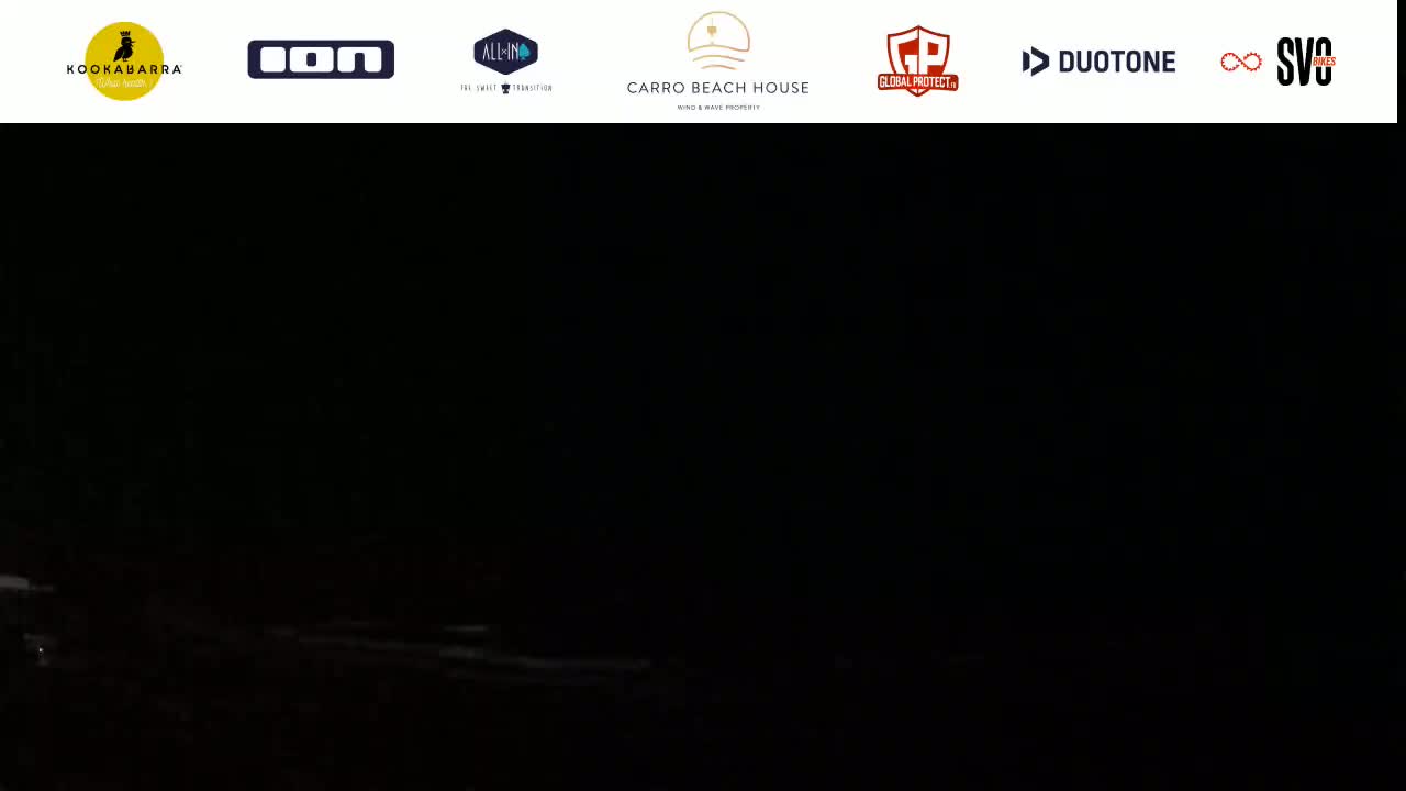 A dark, nighttime scene shows a body of water with faintly visible waves.