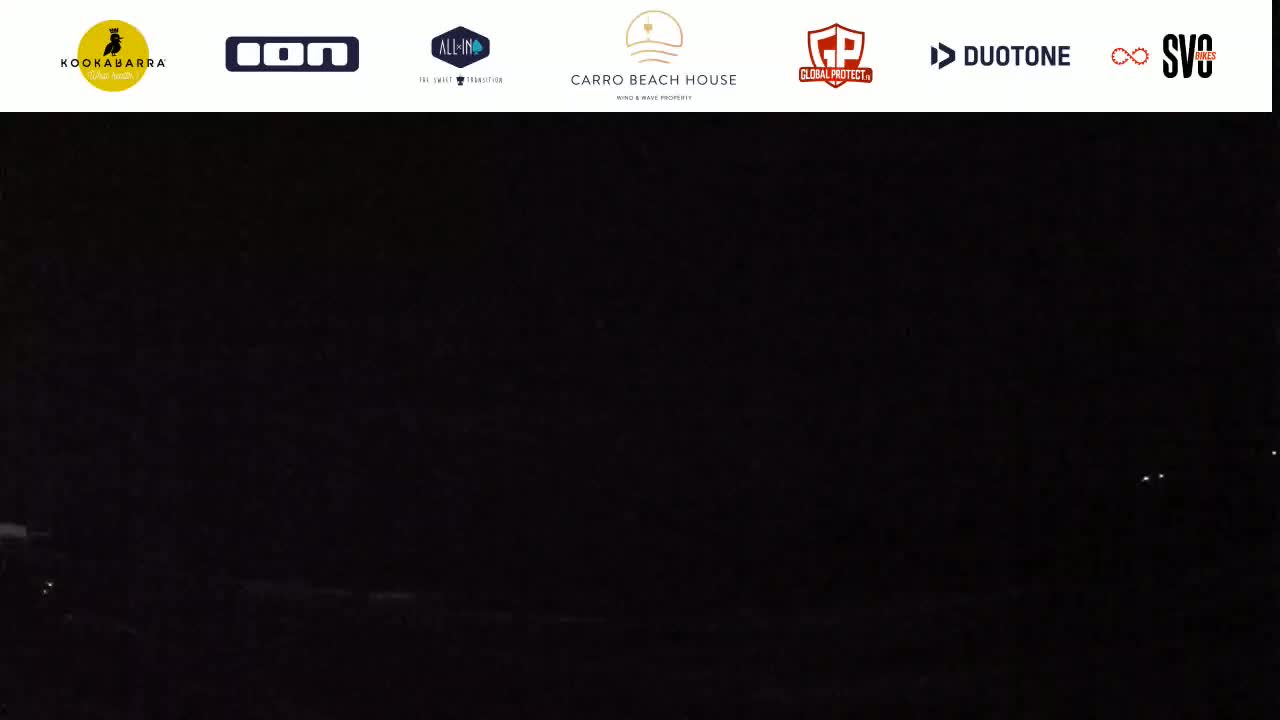 A nighttime, dark image shows a few faint lights in the distance.