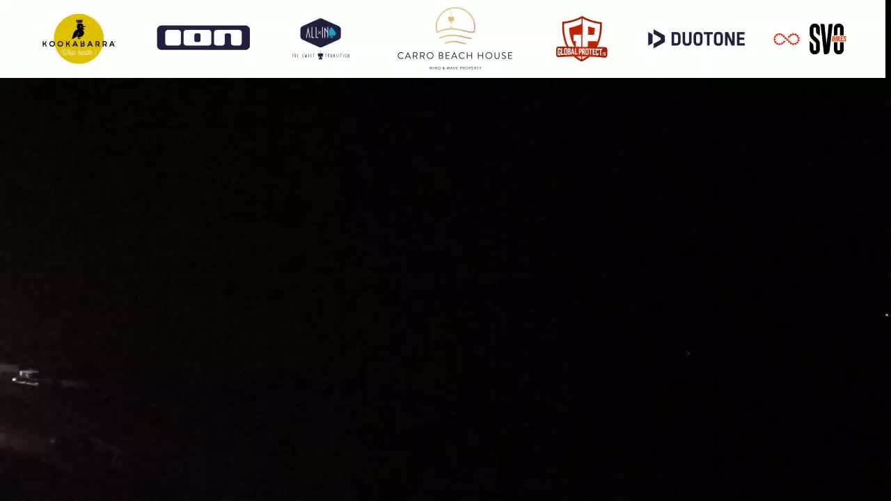 A very dark image shows a few faint lights in the distance at night.