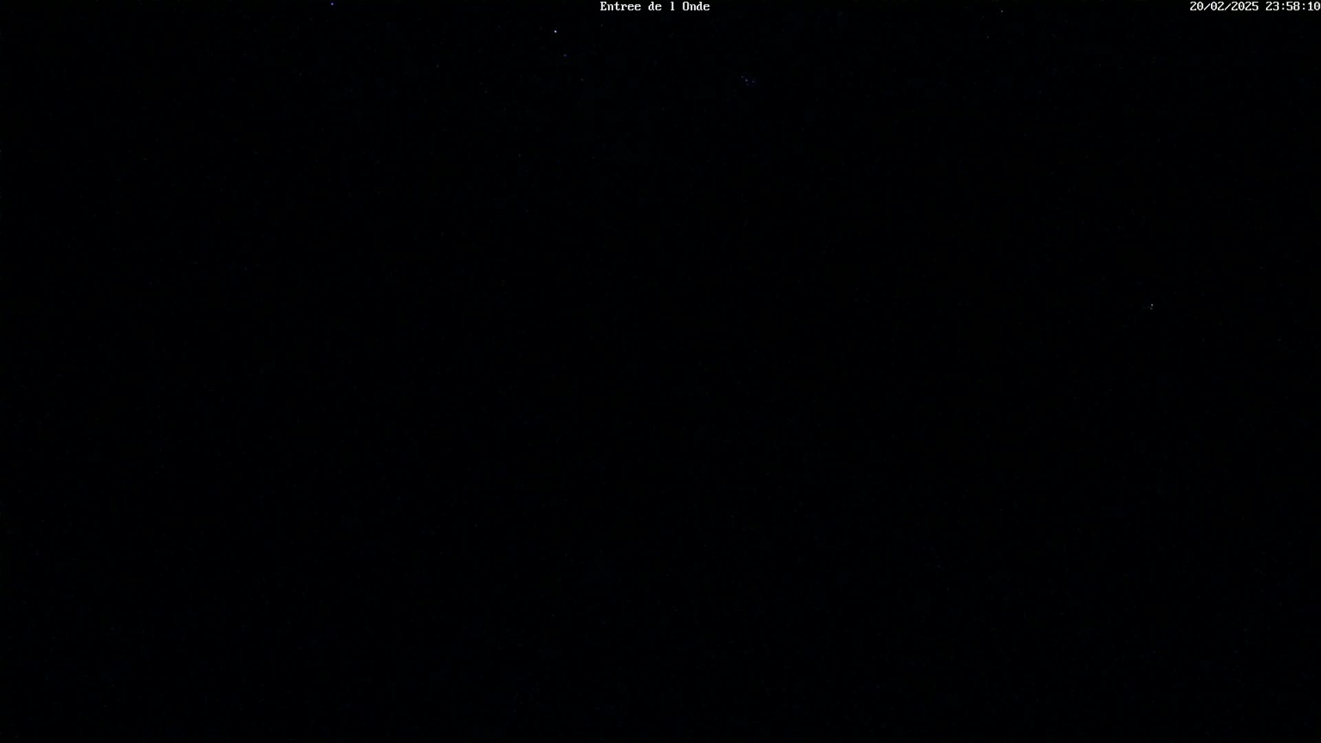 The image shows a completely dark night sky with a few faint stars visible.