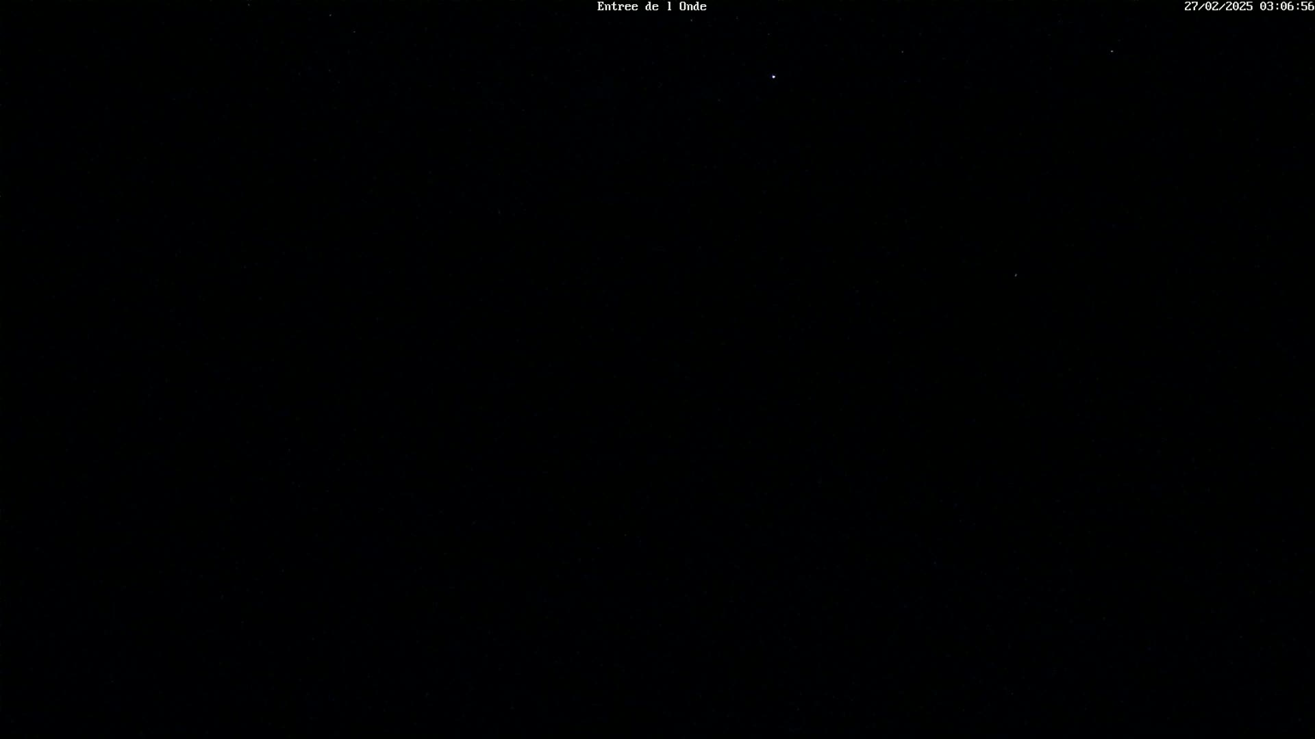 The image shows a dark, night sky with a few faint stars visible.