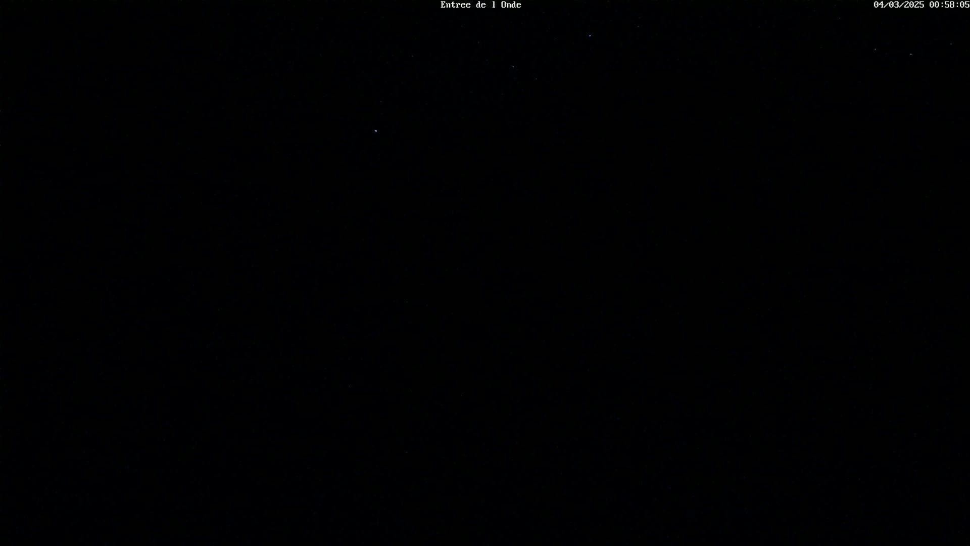 A nighttime image shows a mostly clear, dark sky with a few visible stars.