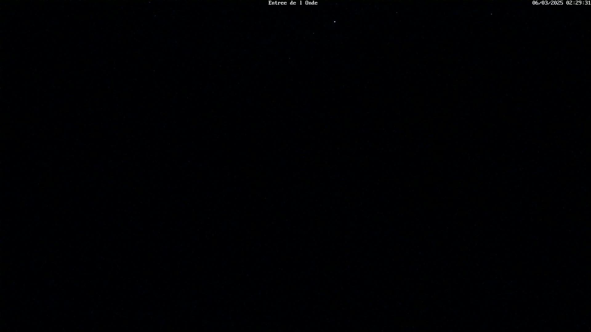 The image is a completely black nighttime scene with a few faint stars visible.