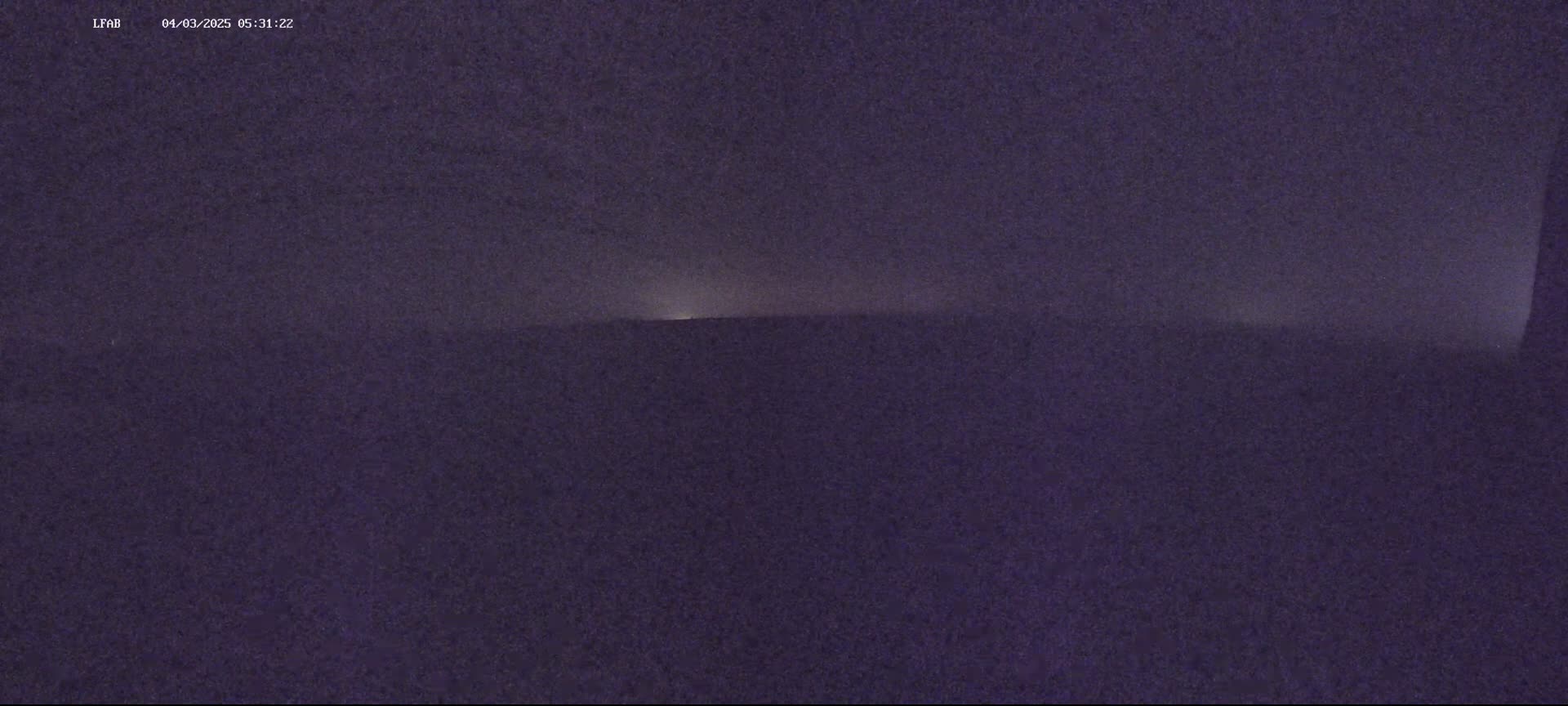 A dark, hazy landscape is visible under a night sky.