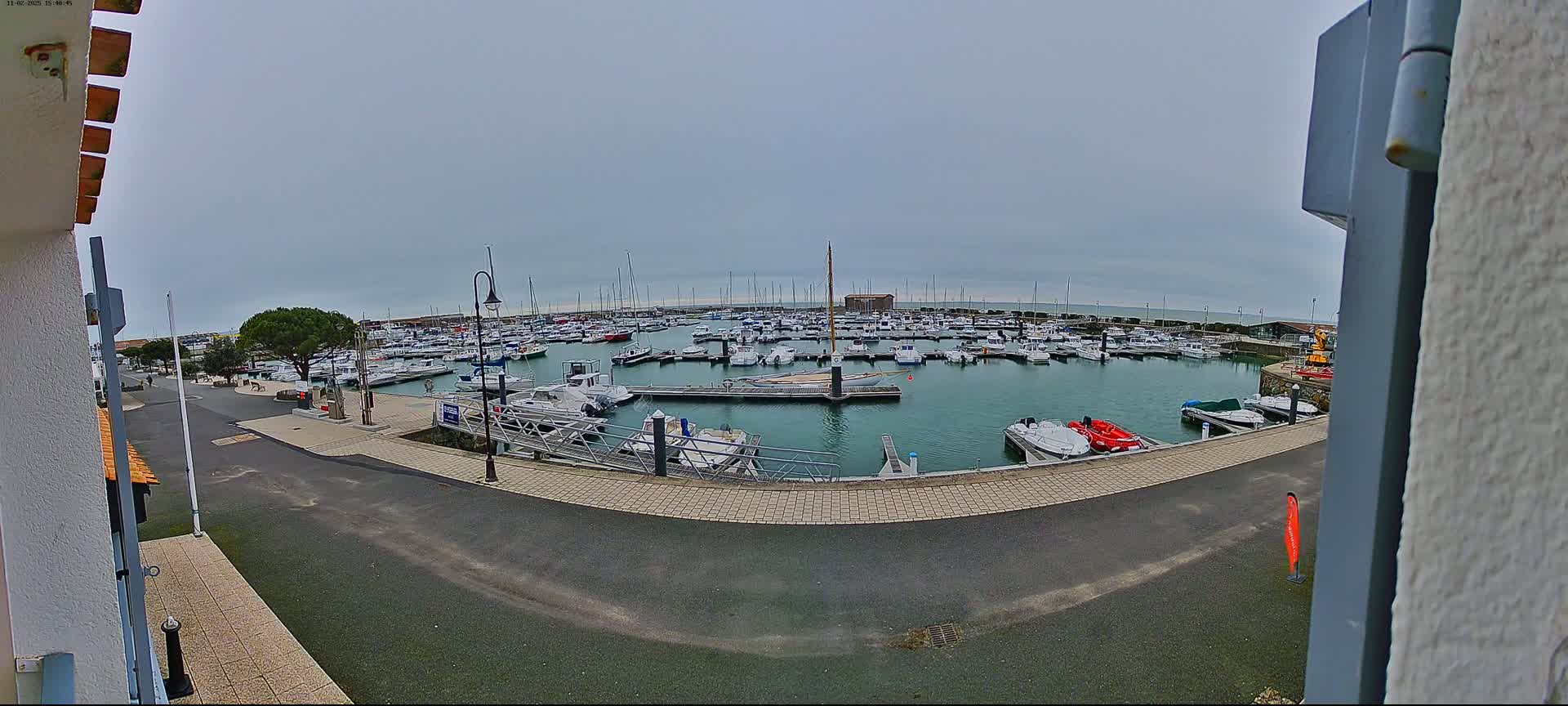 A marina filled with numerous boats is seen on an overcast day.