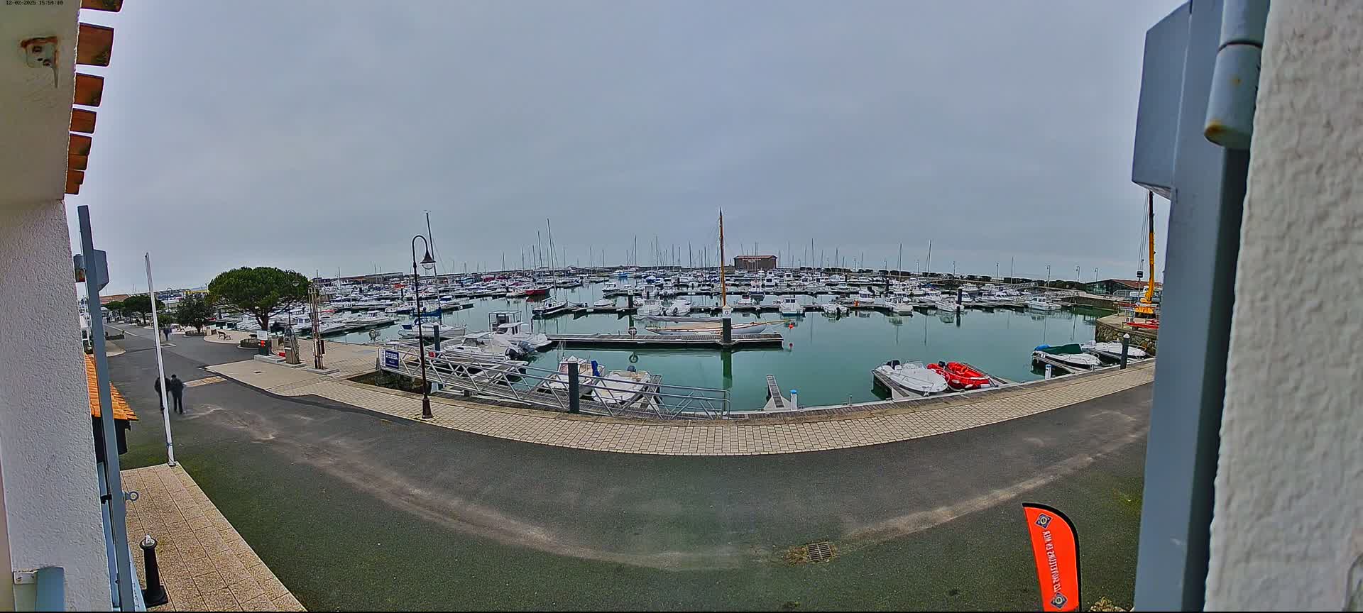 A marina filled with numerous boats on a cloudy day.