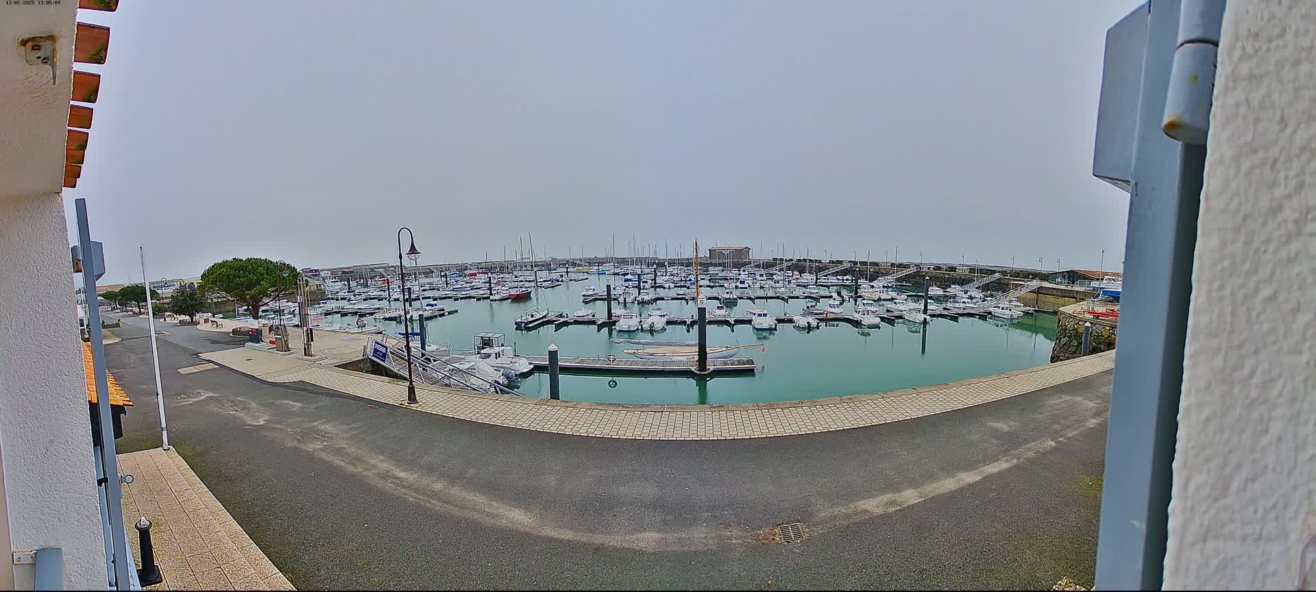 A marina filled with numerous boats is seen on an overcast day.