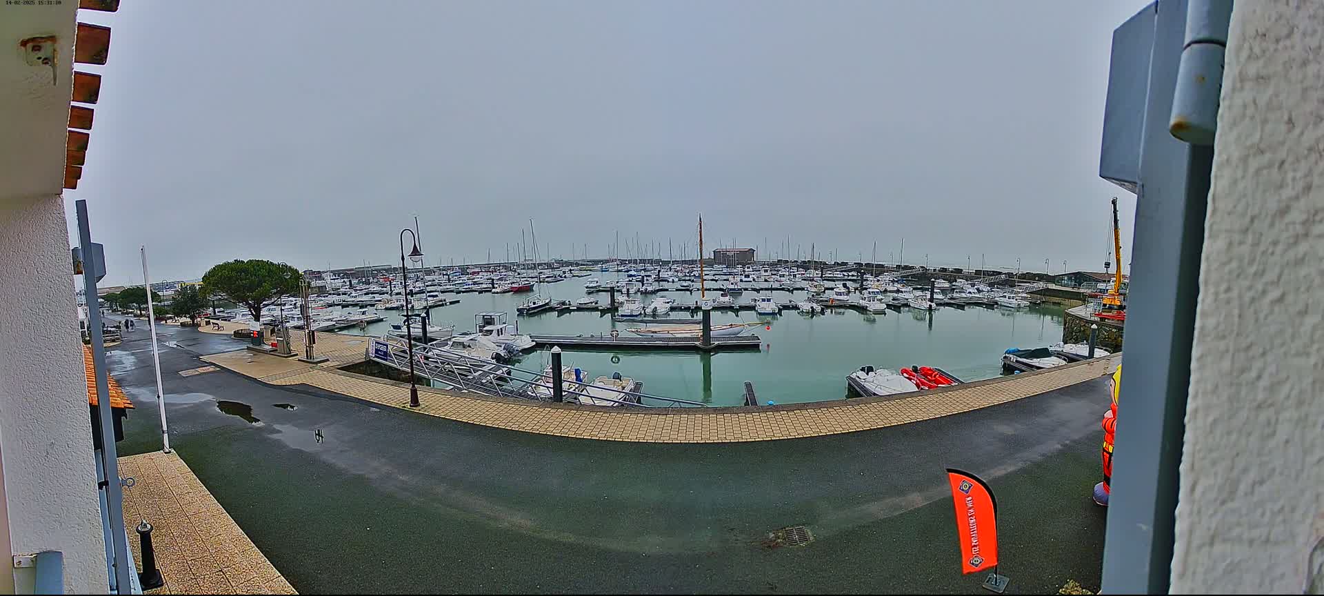 A marina filled with numerous boats is seen on an overcast day.