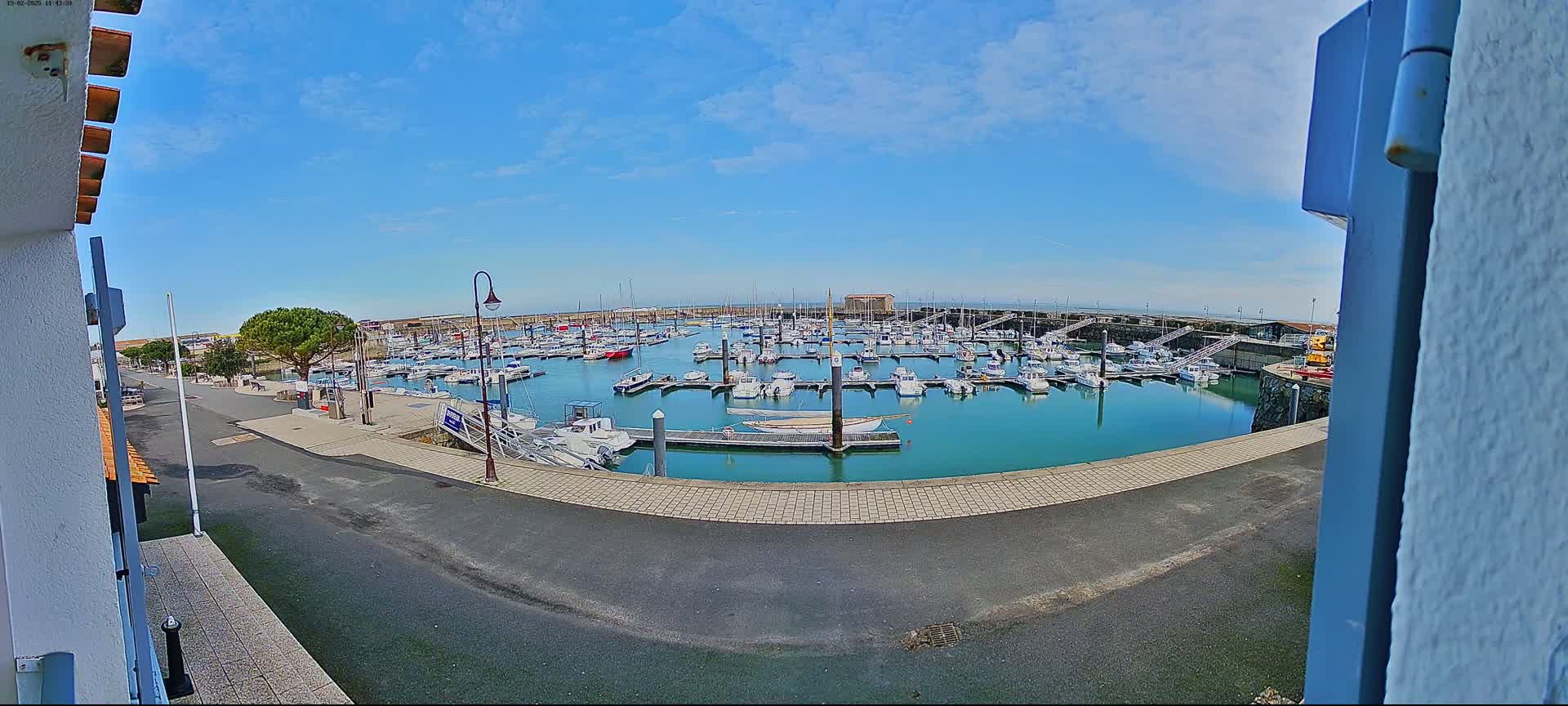 A marina filled with numerous boats is seen on a sunny day.