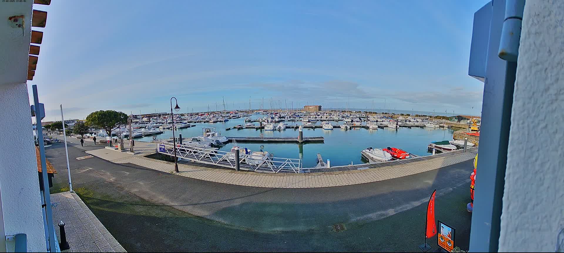 A marina filled with numerous boats is seen on a sunny day.