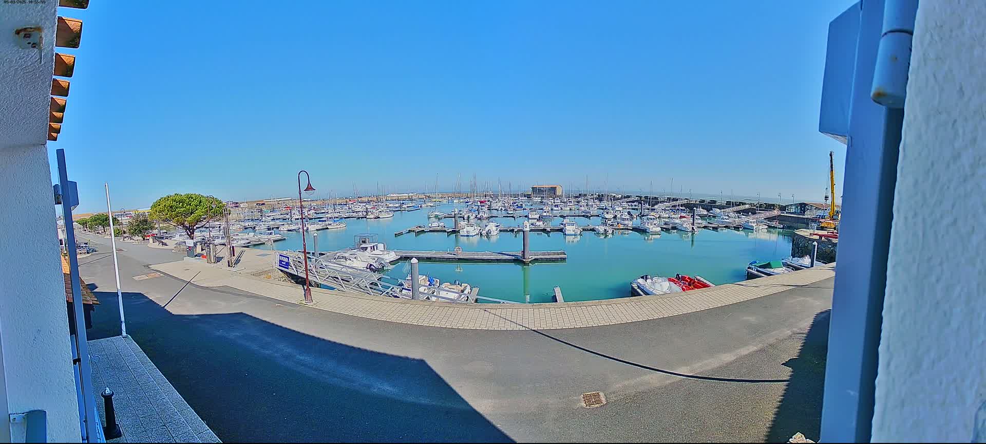 A marina filled with numerous boats is seen on a sunny day.