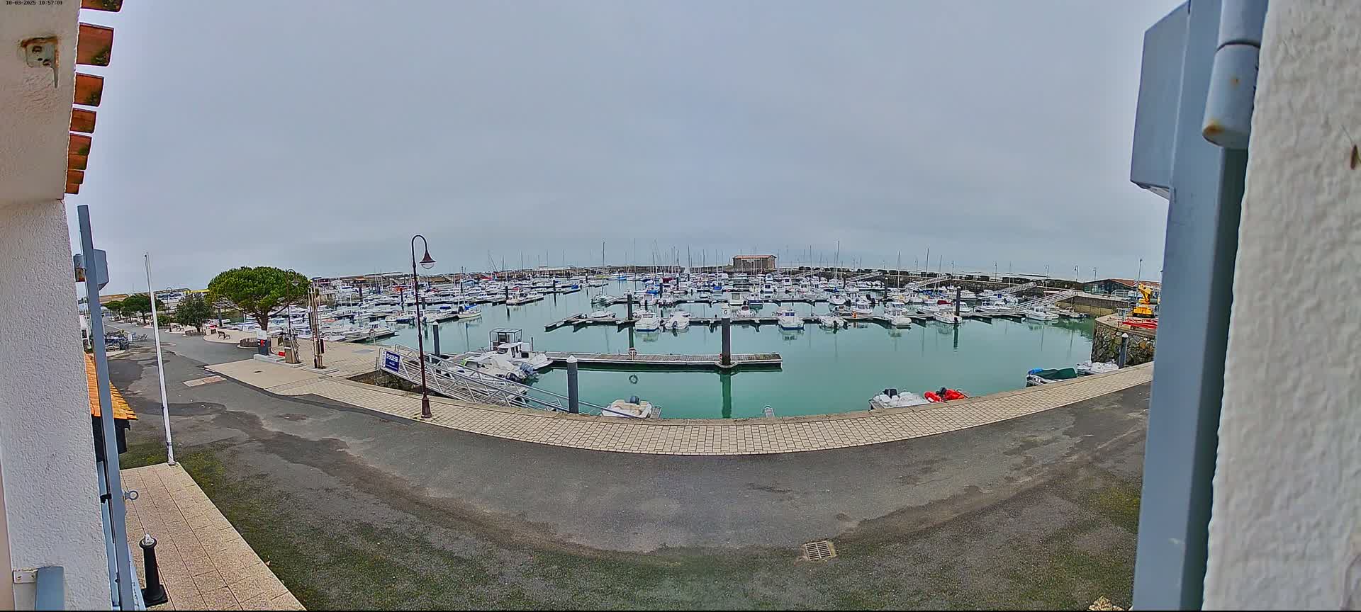 A marina filled with numerous boats is seen on an overcast day.