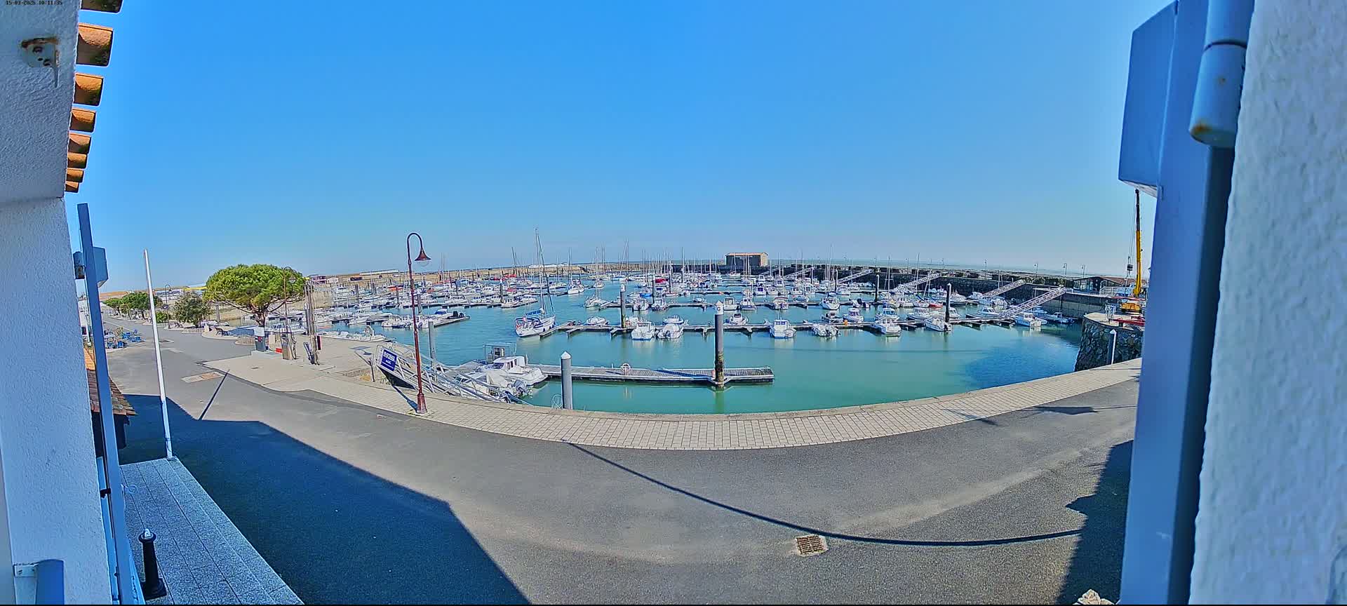 A marina filled with numerous boats is seen on a sunny day.