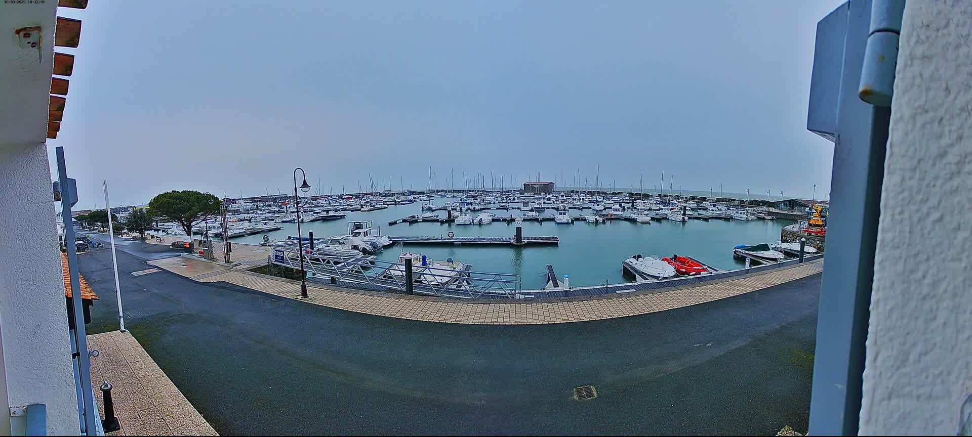 A marina filled with numerous boats is seen on an overcast day.
