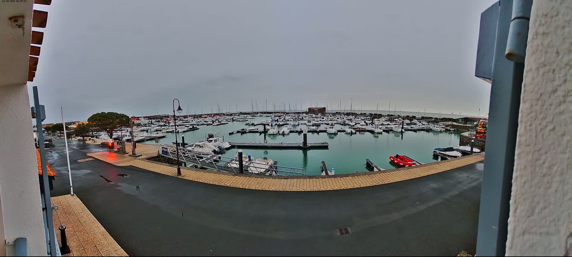 A marina filled with numerous boats is seen on an overcast day.