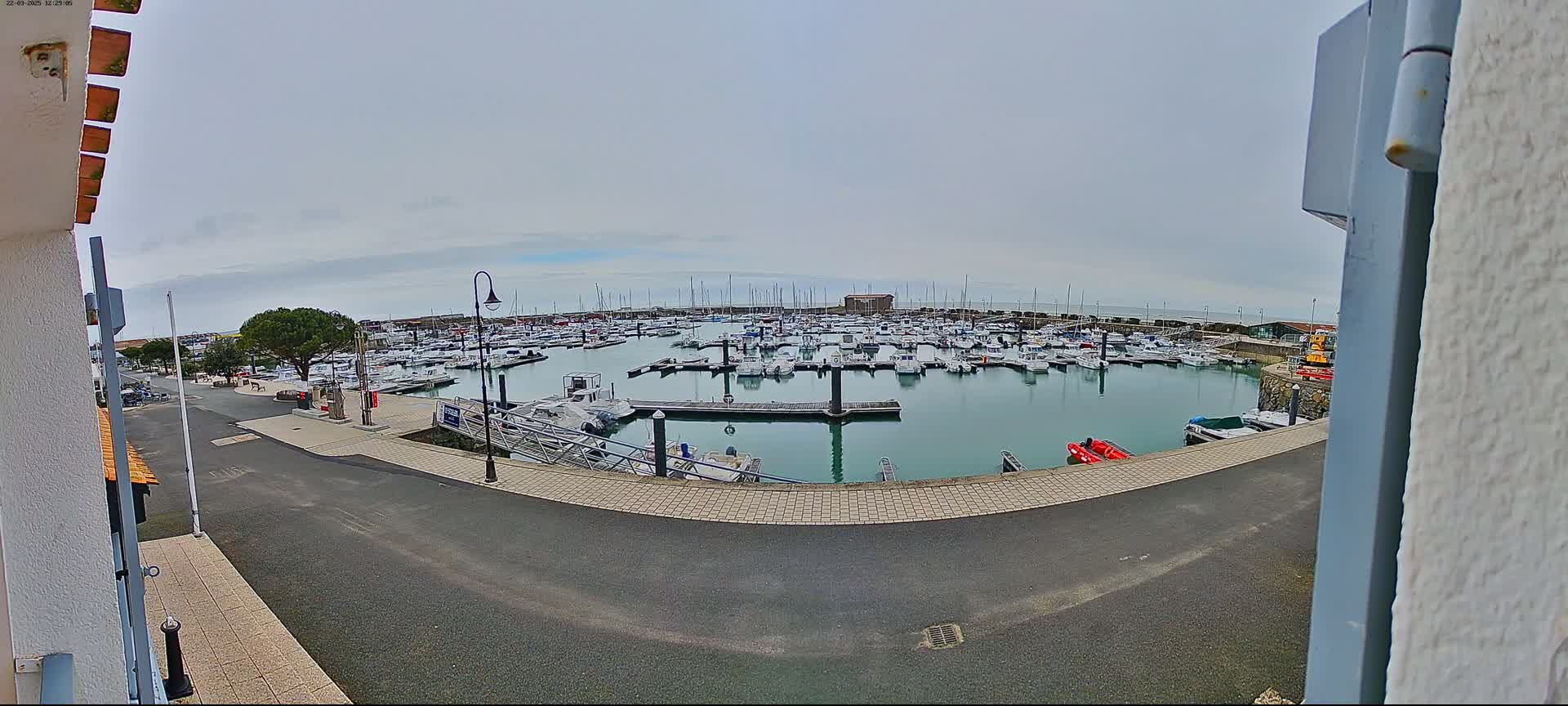 A marina filled with numerous boats is seen on an overcast day.