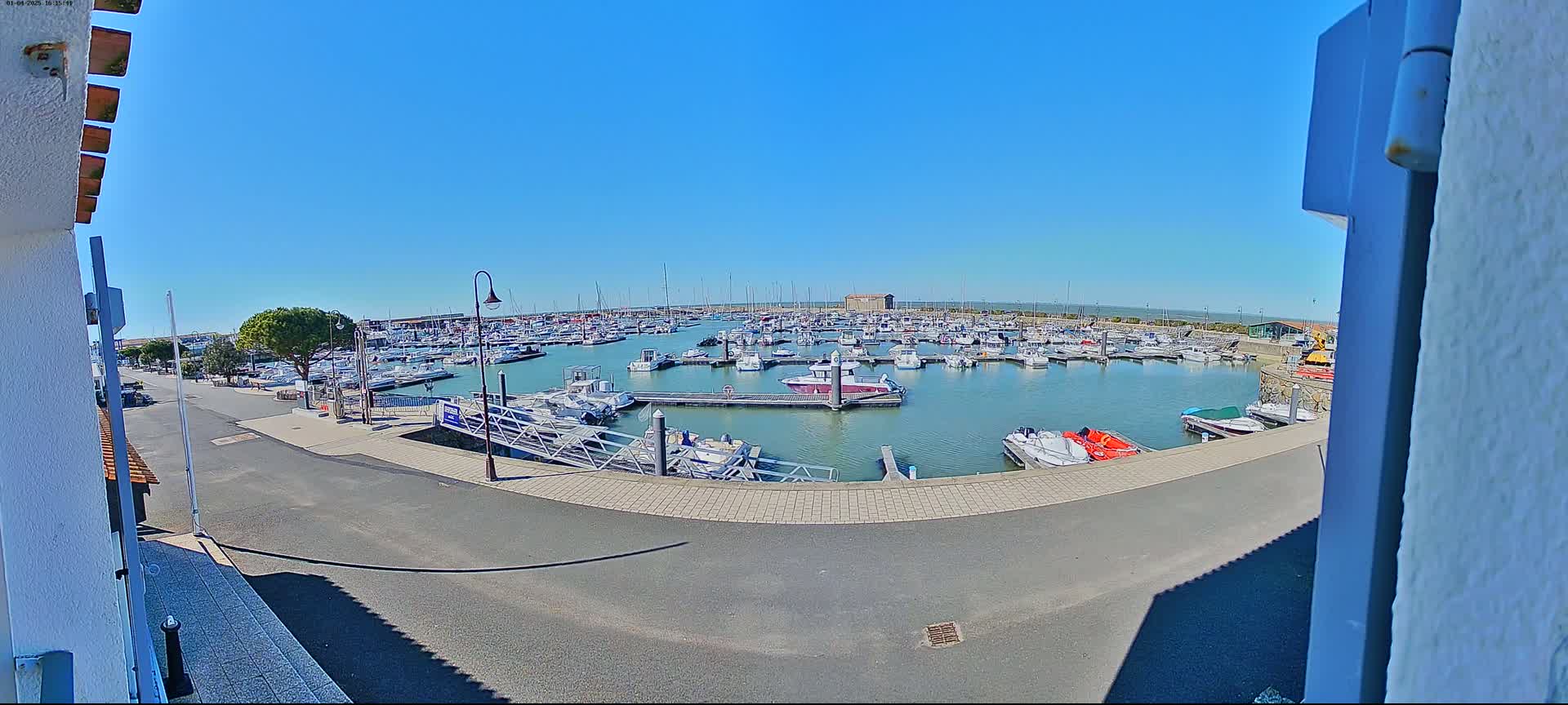 A marina filled with numerous boats is seen on a sunny day.