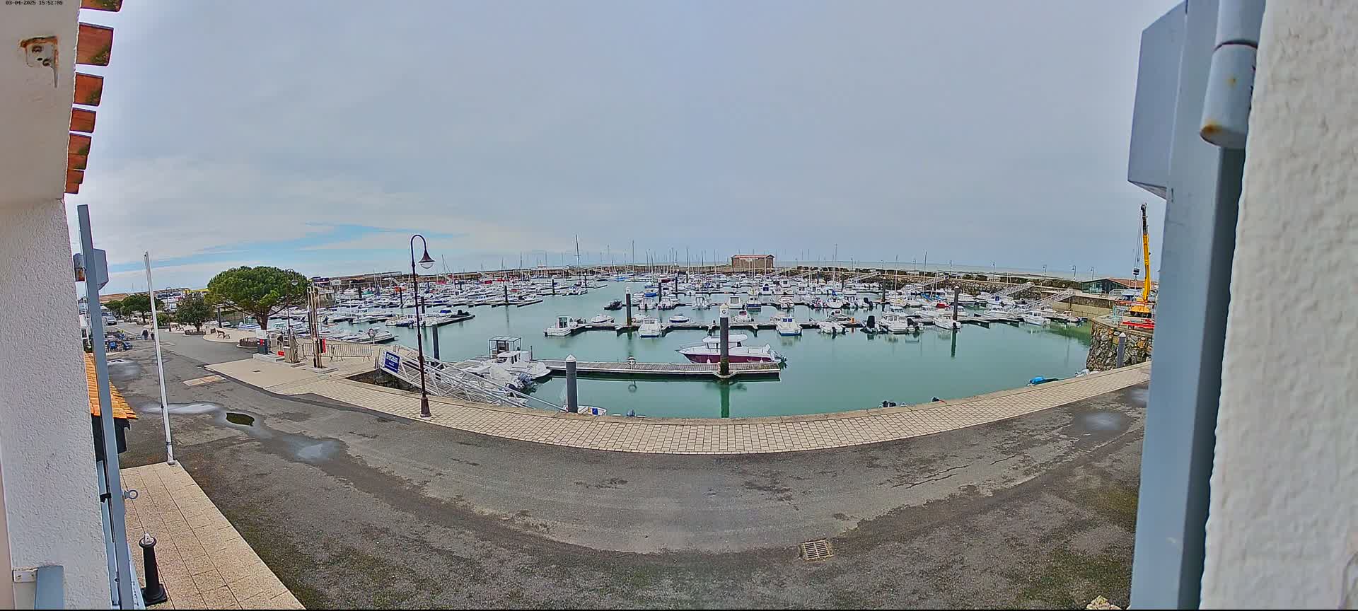 A marina filled with numerous boats is seen on an overcast day.