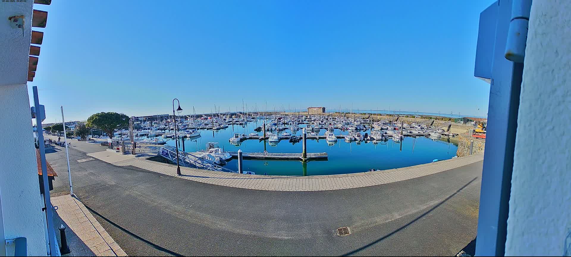 A marina filled with numerous boats is seen on a sunny day.