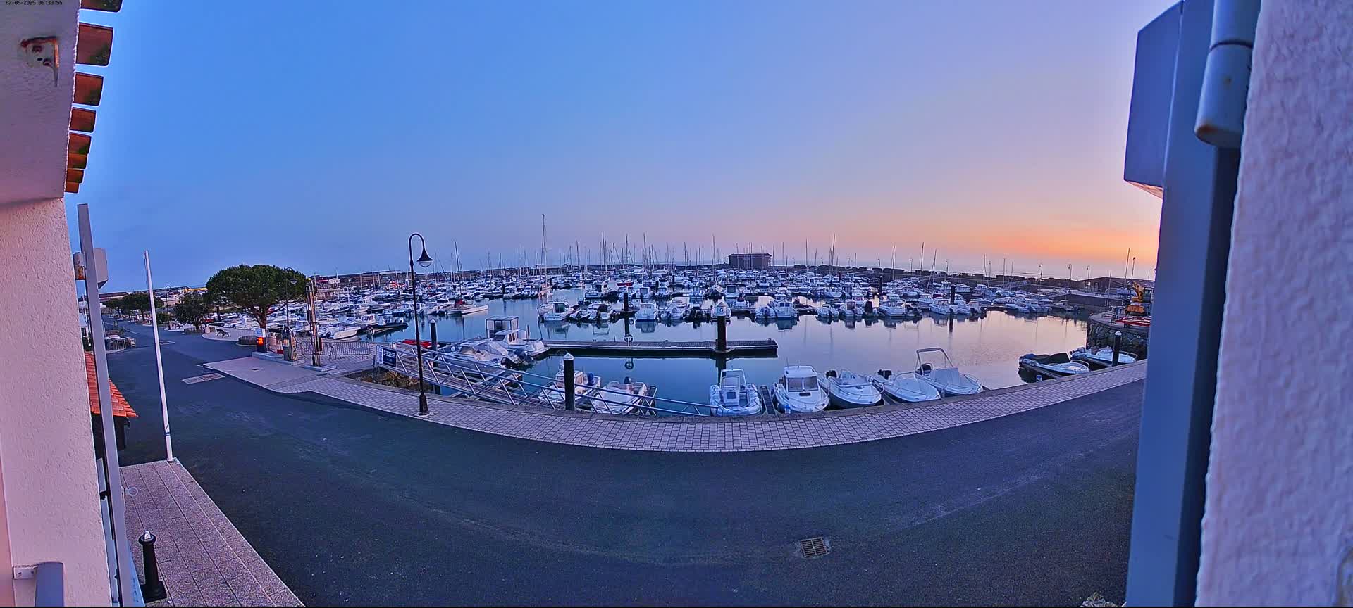 A marina filled with numerous boats at sunset under a clear sky.