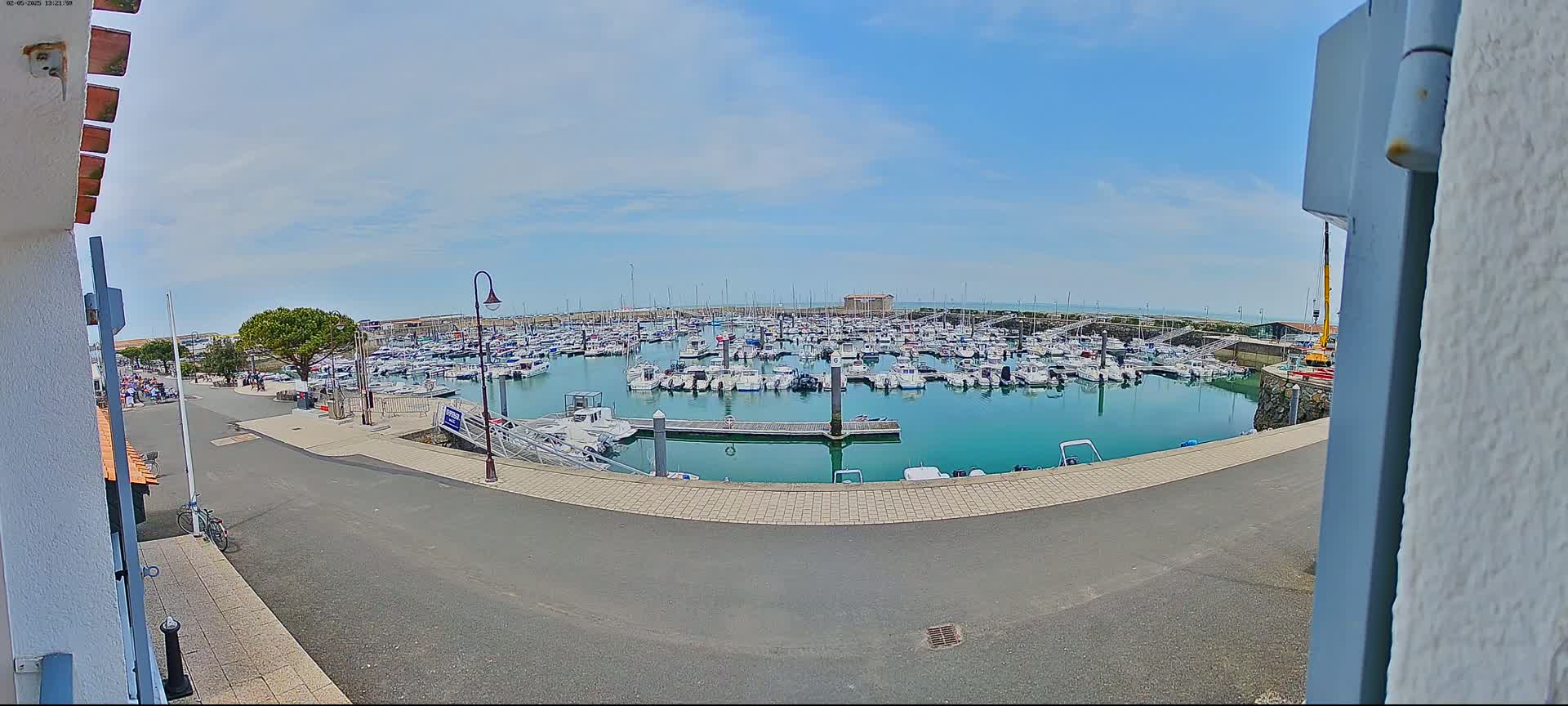 A marina filled with numerous boats is seen on a sunny day.
