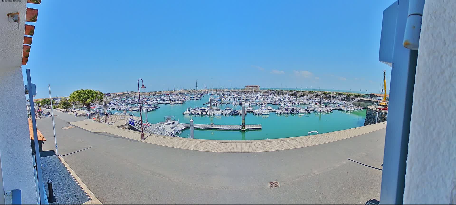 A marina filled with numerous boats is seen on a sunny day.